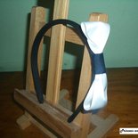 Cerchietto nero con fiocco in raso bianco.