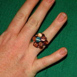 anello con fiorellone e spirali arancione e blu