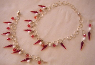 parure collana ,orecchini e bracciale con catena in argento indiano, mezzo cristallo rosso e bianco e cornetti in vetro di murano rosso parure collana ,orecchini e bracciale con catena in argento indiano, mezzo cristallo rosso e bianco e cornetti in vetro di murano rosso