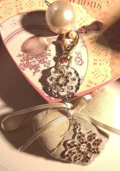Portachiavi gioiello con ciondolo con due fiori tempestati di piccoli strass e cuore imbottito Portachiavi gioiello con ciondolo con due fiori tempestati di piccoli strass e cuore imbottito
