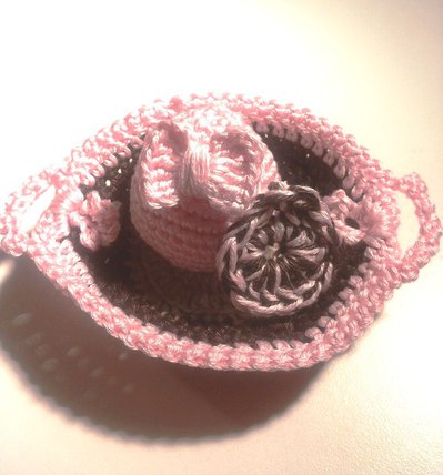 Ovetto pasquale amigurumi con un fiocchetto rosa confetto contenuto in un cestino-vassoio Ovetto pasquale amigurumi con un fiocchetto rosa confetto contenuto in un cestino-vassoio