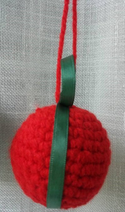 Palla di Natale rossa in lana tecnica amigurumi con rifinitura in nastro seta verde Palla di Natale rossa in lana tecnica amigurumi con rifinitura in nastro seta verde