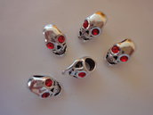 5 Perle teschio foro largo metallo lucido con occhi perle sfaccettate vetro rosso 14x9 mm.