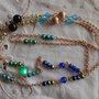 Catenina per occhiali con perle varie di tonalità verde e azzurro e catena dorata, lunghezza cm.80
