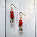 Orecchini dorati pendenti in corallo rosso e cristallo di rocca (quarzo ialino), fatti a mano e Made in Italy. Speciale orecchini estate.