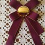 Regala per la festa della Mamma spilla con fiocco realizzata con nastro grosgrain rosso bordeaux ed elemento bijoux centrale