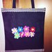 Borsa in tessuto decorata con fiori a uncinetto 