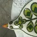 Uccellino porta mestoli di ceramica, modellato e dipinto a mano con motivo di occhi di pavone  sul verde