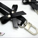 Manico per borsa, 62 cm. in cuoio nero, ha 2 fiocchi laterali in cuoio, rivetti e moschettoni extra lusso colore argento 