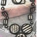 Lunga collana di ceramica con motivi bianco e nero con semisfere, lenti e rettangoli
