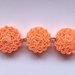Bracciale di colore arancione con perline di cartoncino ondulato fatte a mano