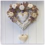 Cuore in vimini con rose e cuori di lino bianco, rametti di feltro beige e lilla