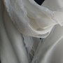 Pashmina in caldo cotone di colore bianco con delicato merletto lungo i lati.