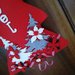 Albero fuoriporta rosso, decorato da una scritta, da alberi in feltro e stelle di Natale 