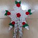 Grande stella bianca decorata con roselline e foglie di pannnolenci e lungo nastro con delicati disegni natalizi.