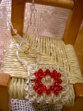Collana con tubetti trasparenti e un ciondolo quadrato composto da perle di vetro trasparenti e rosse