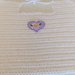 Bavaglino per neonati realizzato a uncinetto con filo di scozia di colore bianco ed impreziosito da un cuoricino viola
