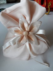 Bomboniera/segnaposto: Sacchetto per confetti cucito a mano imbottito nel color rosa cipria ornato con nastro e fiore perlescente in fimo