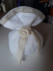 Bomboniera/Segnaposto: Sacchettino per confetti imbottito in lino bianco chiuso con una rosellina in stoffa bordato con ricamo floreale 