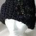 Elegante cappello di lana di colore nero realizzato a uncinetto con fiore nero e oro.