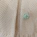 Ampia mantellina -coprispalle realizzata in lana di colore panna  con spilla a forma di fiore che orna e permettere di chiudere lamantellina 
