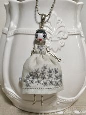 Collana lunga dolls di ceramica dipinta con vestito di lino grigio ricamato a mano.