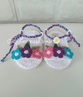 Sandali bianchi per neonata, con fiori turchese, viola e rosa, allacciate alla caviglia da un cordoncino intrecciato, 100% cotone italiano.
