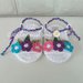Sandali bianchi per neonata, con fiori turchese, viola e rosa, allacciate alla caviglia da un cordoncino intrecciato, 100% cotone italiano.