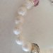 Braccialetto realizzato con perle bianche opache puntinate, con inserti in metallo e pietre colorate.Braccialetto realizzato con perle bianche opache puntinate, con inserti in metallo e pietre colorate.