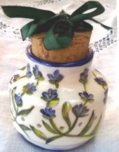 Piccolo vaso di ceramica porta aromi, forato intorno con tappo in sughero e fiocco verde