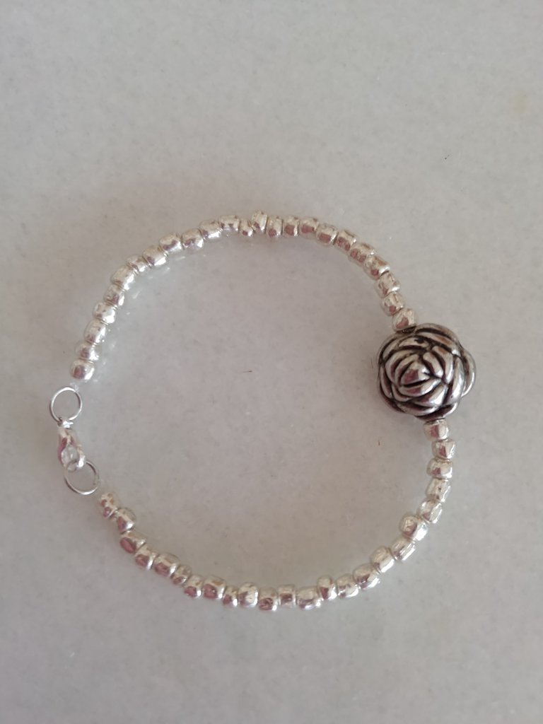 Braccialetto realizzato a mano con perline color argento con al cen