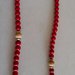 Collana realizzata con perle rosse ed inserti di perle  di legno chiaro e distanziatori in metallo