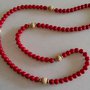 Collana realizzata con perle rosse ed inserti di perle  di legno chiaro e distanziatori in metallo