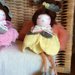 Bomboniere che rappresentano bamboline su fiore rosa, azzurro, giallo e verde