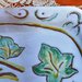 Vassoio di maiolica svuotatasche, manufatto dipinto con ramo con foglie d'edera contorni incisi