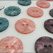 5 bottoni mm.21, in resina colore prugna, cangianti effetto madreperla, attaccatura 2 fori 