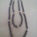 Collana realizzata con perle grigie alternate da perle filigranate color argento