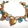 Bracciale dorato cuore croce, charms azzurre Swarovski. 