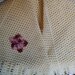 Ampia mantellina-coprispalle  realizzata in pura lana color giallo chiaro e impreziosita da un fiore di filo sfumato
