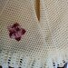 Ampia mantellina-coprispalle  realizzata in pura lana color giallo chiaro e impreziosita da un fiore di filo sfumato