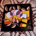  Piastrella sottopentola manufatta di ceramica dipinta con smalti su fondo nero disegno a colori vivaci di mele e foglie bicolori