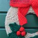 Ghirlanda natalizia fatta a mano con fiocco rosso e bacche uncinetto
