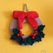 Ghirlanda natalizia fatta a mano con fiocco rosso e bacche uncinetto