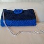 Elegante pochette realizzata in fettuccia blu e azzurra con chiusura a calamita e tracolla in acciaio