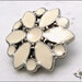 Bottone gioiello mm. 24, in metallo colore argento, fiore bianco smaltato, attaccatura con gambo 