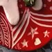 decorazione natalizia 1 palla schiacciata di ceramica manufatta con elementi in rilievo e motivi con decoro graffito, su un fondo rosso. 