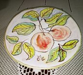 Piccolo piatto di maiolica manufatto dipinto a mano con la tecnica ad acquerello con motivo di un rametto di ciliege con foglie