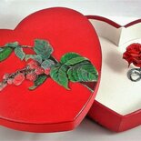 Scatola regalo a forma di cuore con coperchio decorato e una rosa rossa custodita all'interno