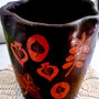Vaso di ceramica lucidato a cera, maufatto di creta rossa su fondo nero motivi diversi  di foglie graffite che fanno risaltare il cotto sottostante 