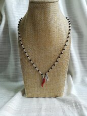 Collana girocollo stile rosario con filo di colore argento, cristalli neri e ciondoli con lettera e cornetto portafortuna rosso.
